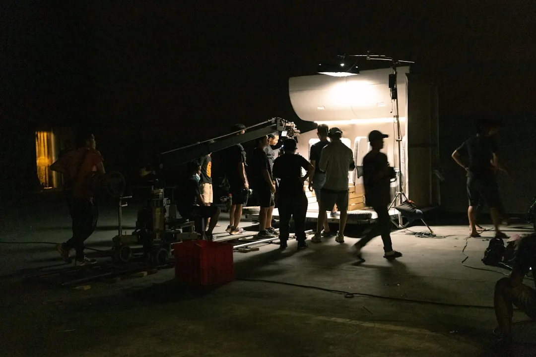 Film crew gathered on a nighttime set, evoking the production of Agent Kim Reactivated