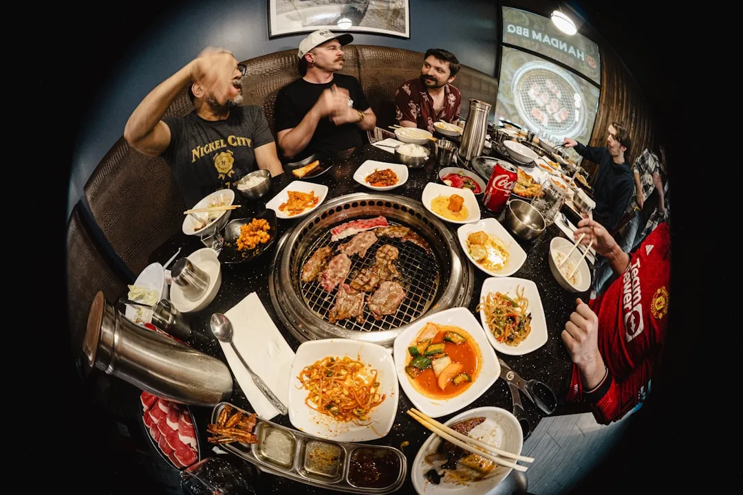 Friends enjoying korean barbecue with many side dishes