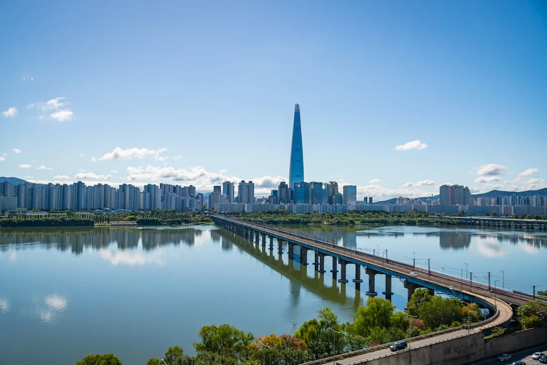 Modern cityscape with a tall skyscraper and bridge over river