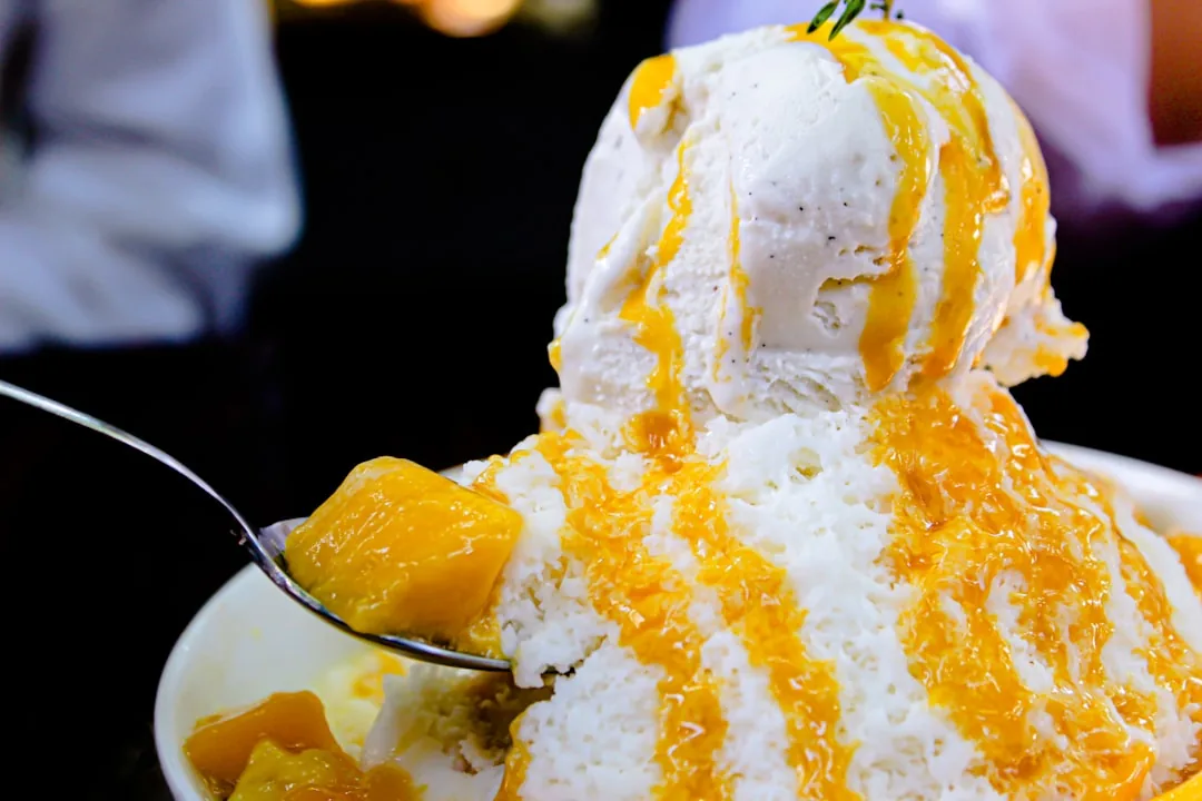 Korean bingsu shaved ice dessert served in a black ceramic bowl