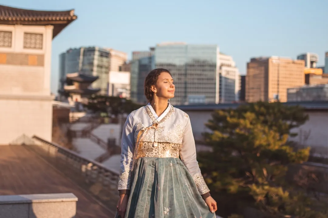 woman in white and blue dress standing on brown wooden bridge during daytime