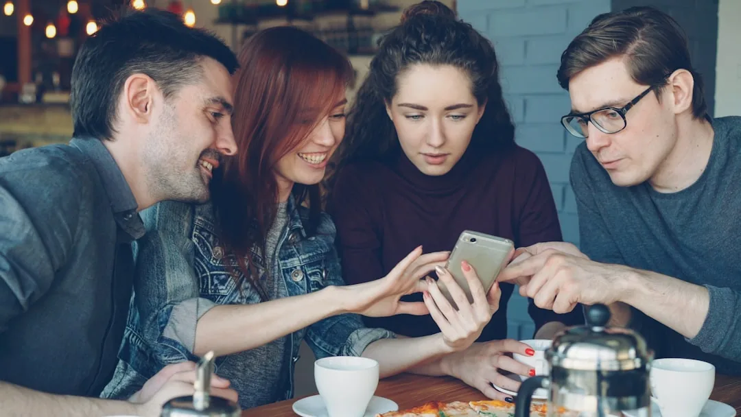 Friends are looking at a phone together.