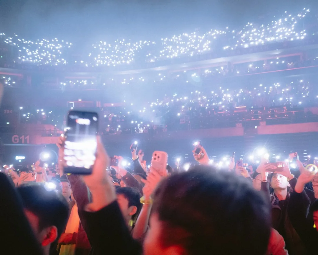 Fans photographing a K-pop stage with their phones