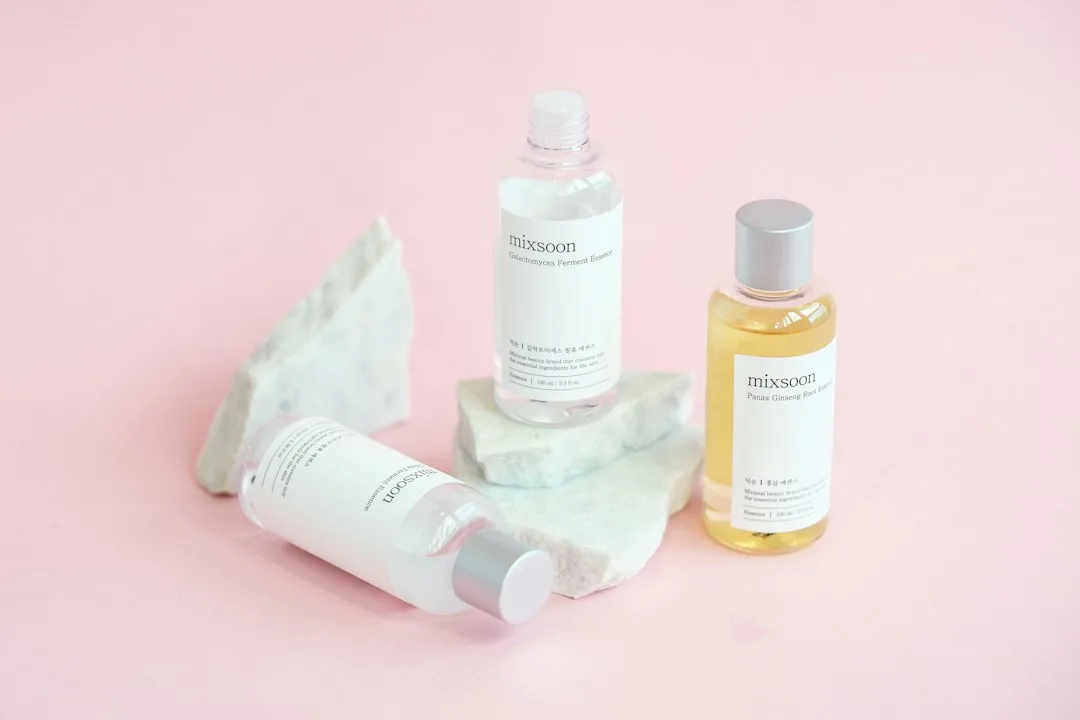 Skincare bottles are displayed on marble rocks