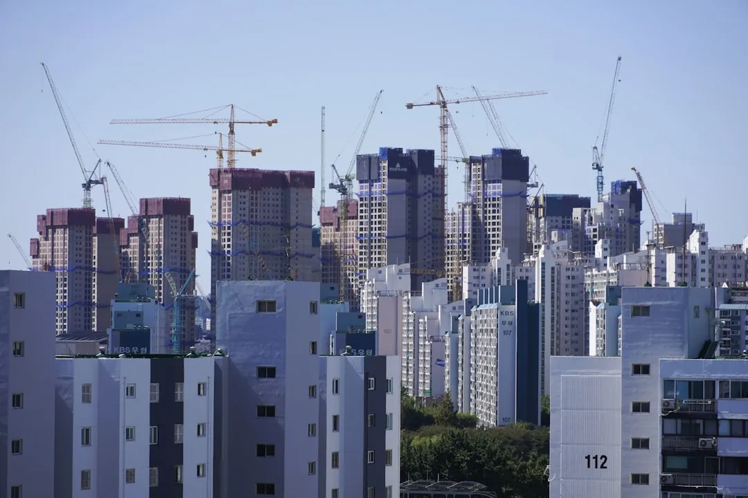 High-rise apartment towers under construction in Seoul, illustrating the gap between exclusive and supply area